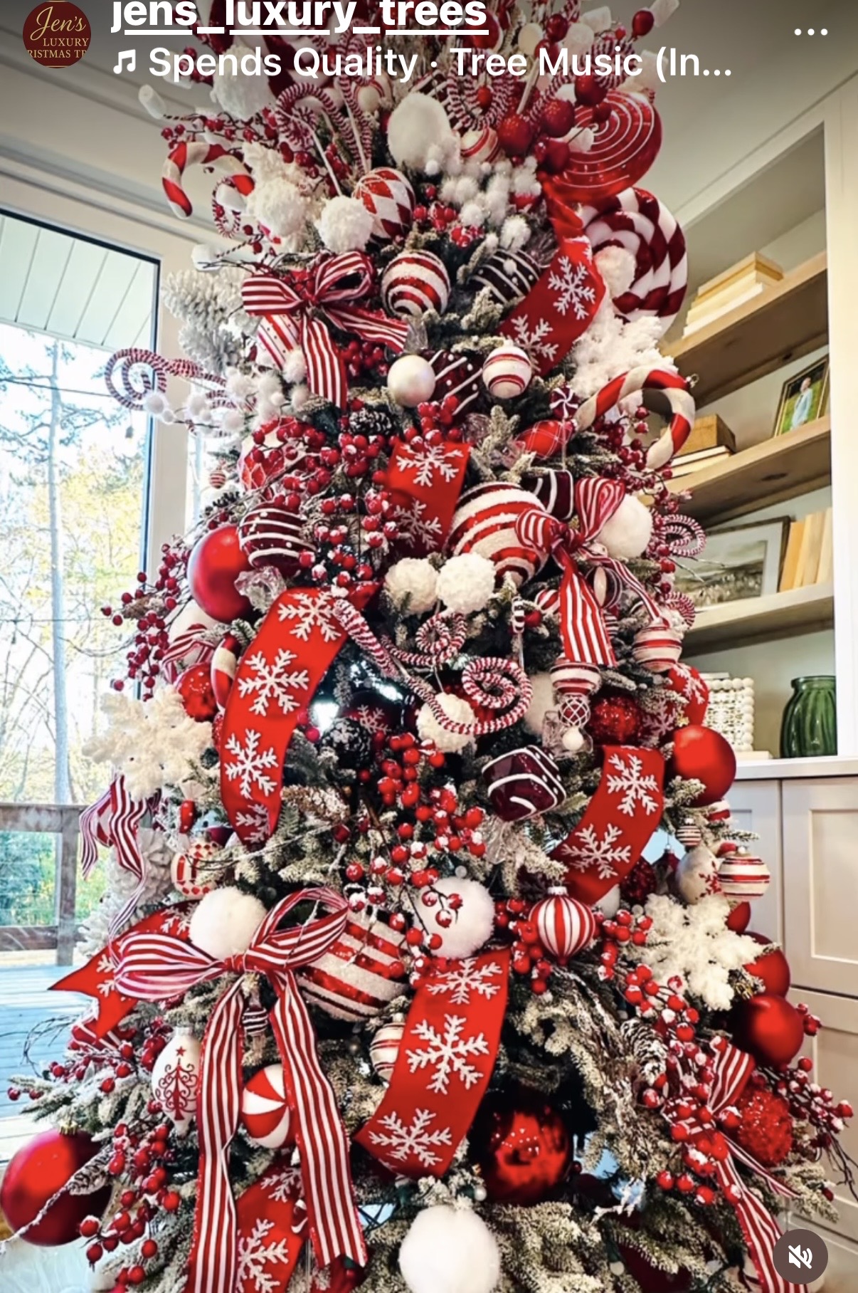 Tall flocked Christmas tree styled in red and white with snowflake ribbon, candy cane picks, and oversized peppermint ornaments