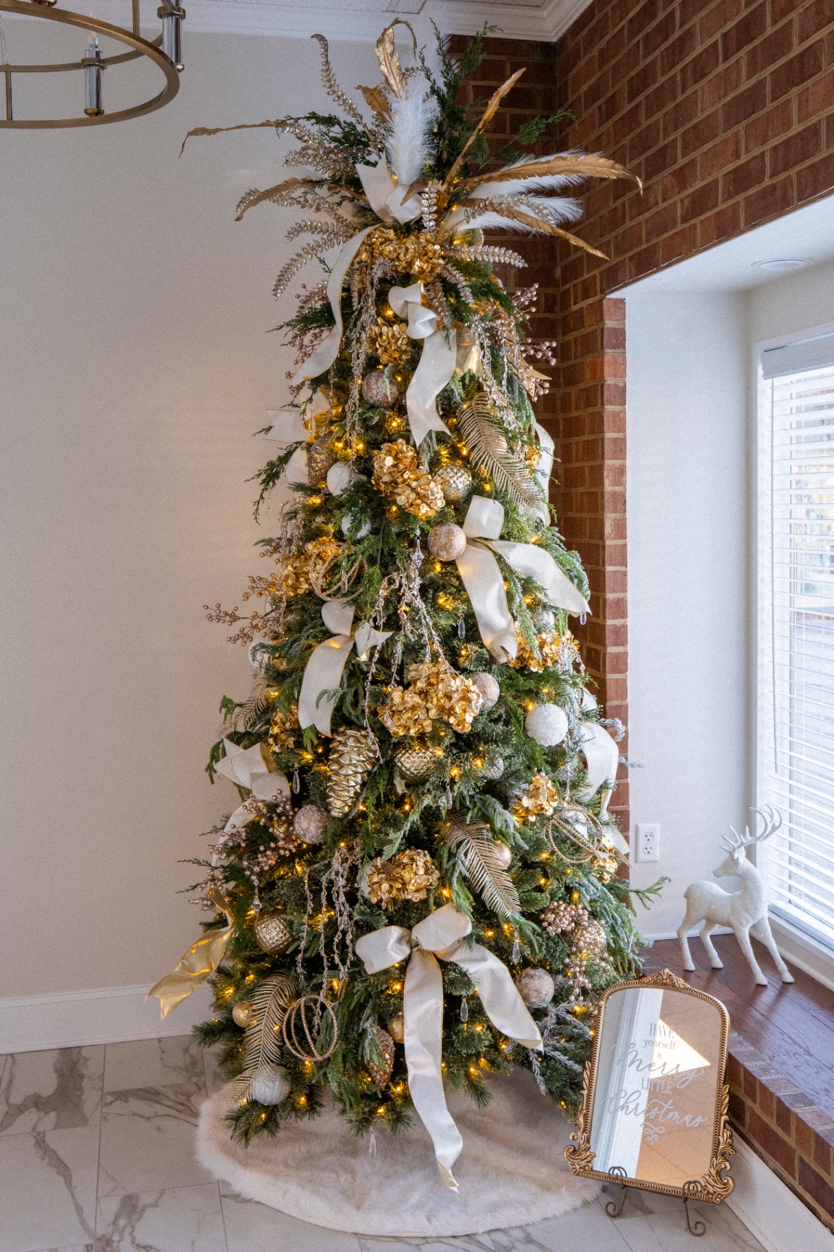 Champagne and gold Christmas tree with feathers and hydrangea
