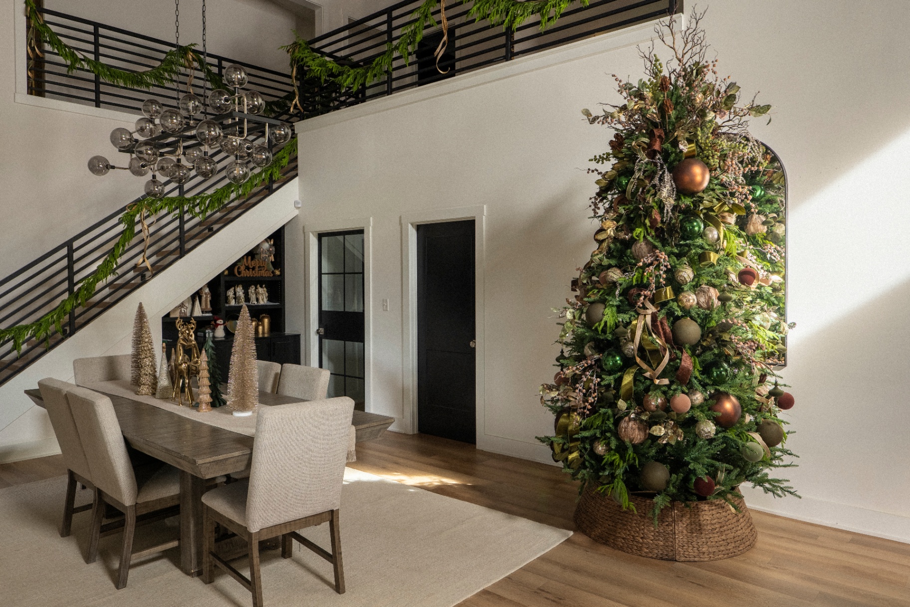 Modern luxe woodland Christmas tree beside a dining room